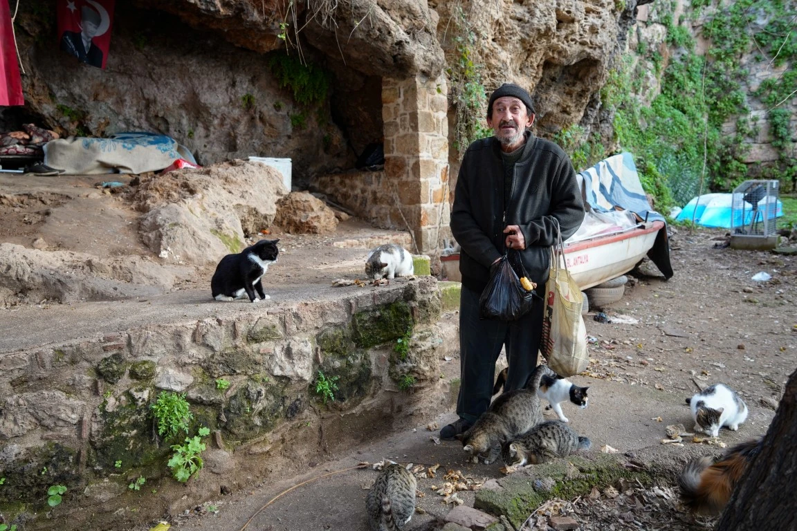 Antalya falezlerindeki tarihi surlarda 4 yıldır kedileriyle birlikte yaşayan 63 yaşındaki Hüseyin Urlu, insanlardan uzak sade yaşamıyla dikkat çekiyor. 