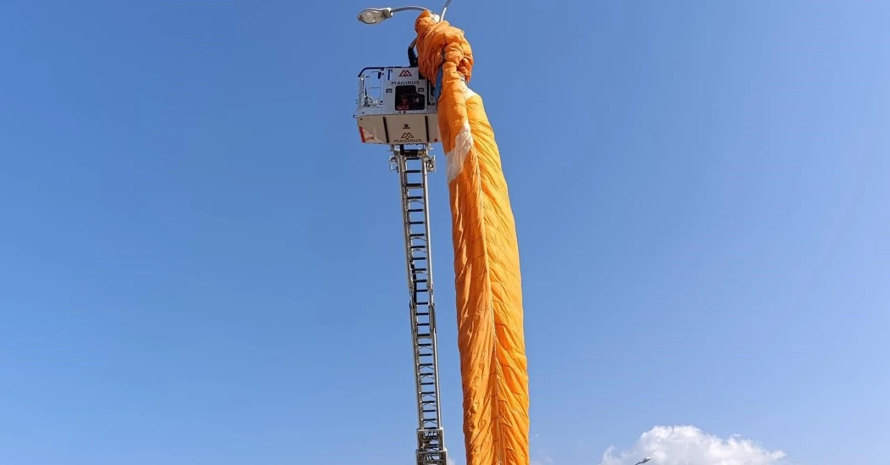 Paraşütçünün gökyüzü sefası aydınlatma direğine takıldı
