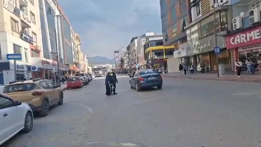 Yolun karşısına geçmek isteyen yaşlı kadına polis yardım etti
